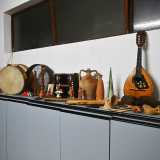 I tre ci conducono al piano interrato all�interno di una stanza gremita di strumenti musicali di tutti i tipi e dimensioni provenienti da ogni parte d�Italia e del mondo. Blasi ci indica tamburelli, flauti, una fisarmonica, un liuto...
